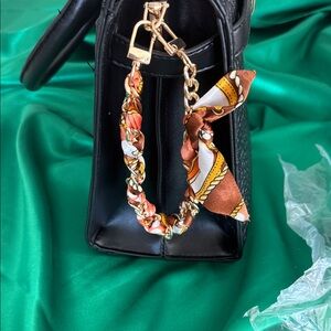 Gold hardware Handbag charm with brown, gold white scarf.